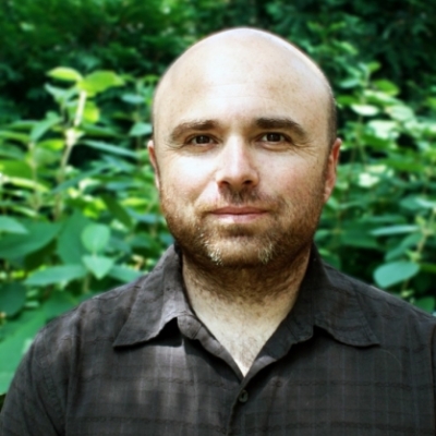 Dr. Sasha Spektor standing in front of greenery