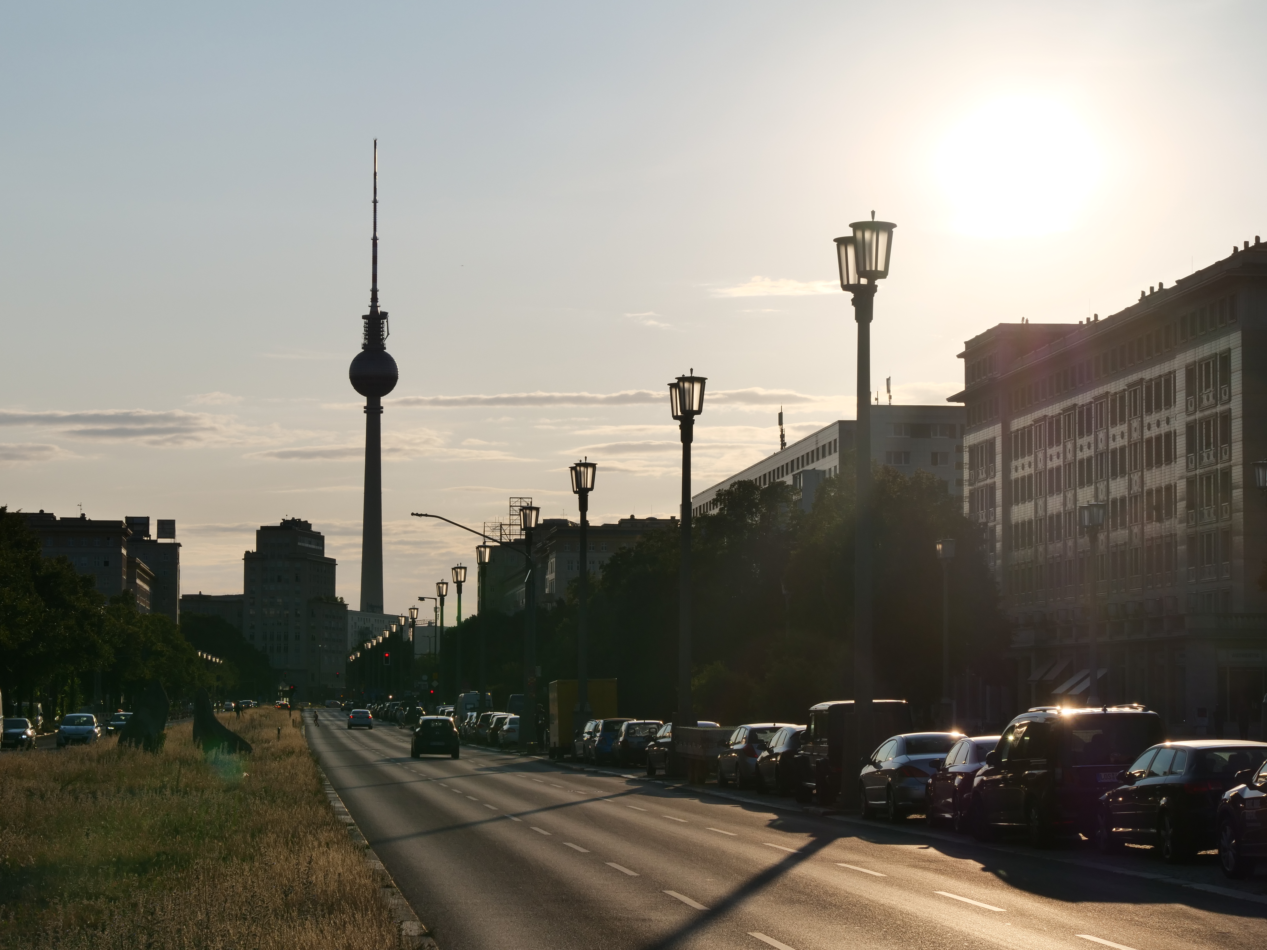 A Berlin street in the shadow of sunset. The television tower can be seen in the background with the cityscape.